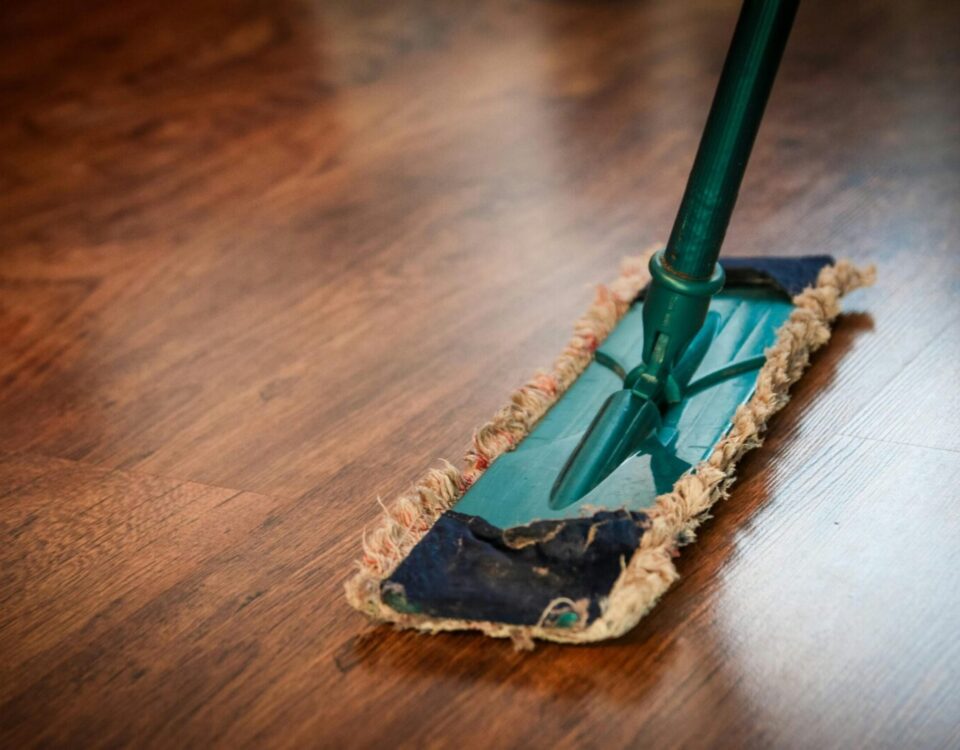 A detailed view of a mop cleaning a wooden floor, showing texture and pattern.